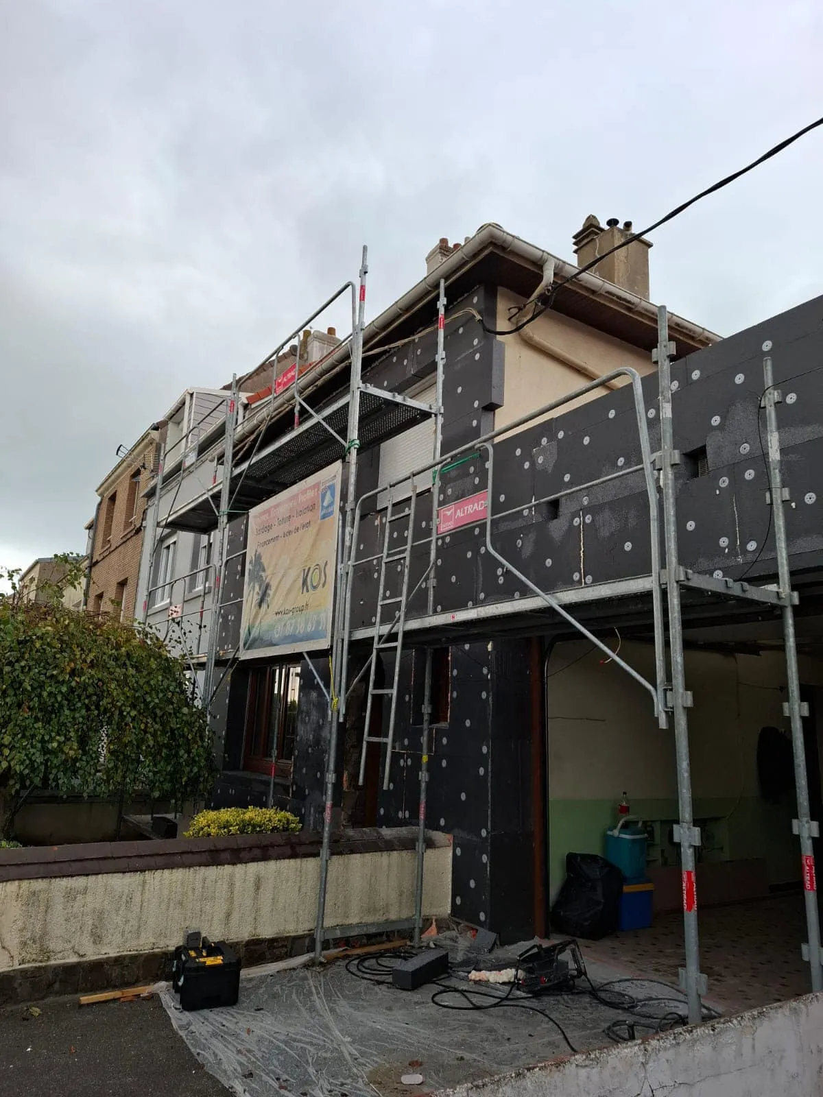 Échafaudage et panneaux isolants fixés sur la façade pendant les travaux