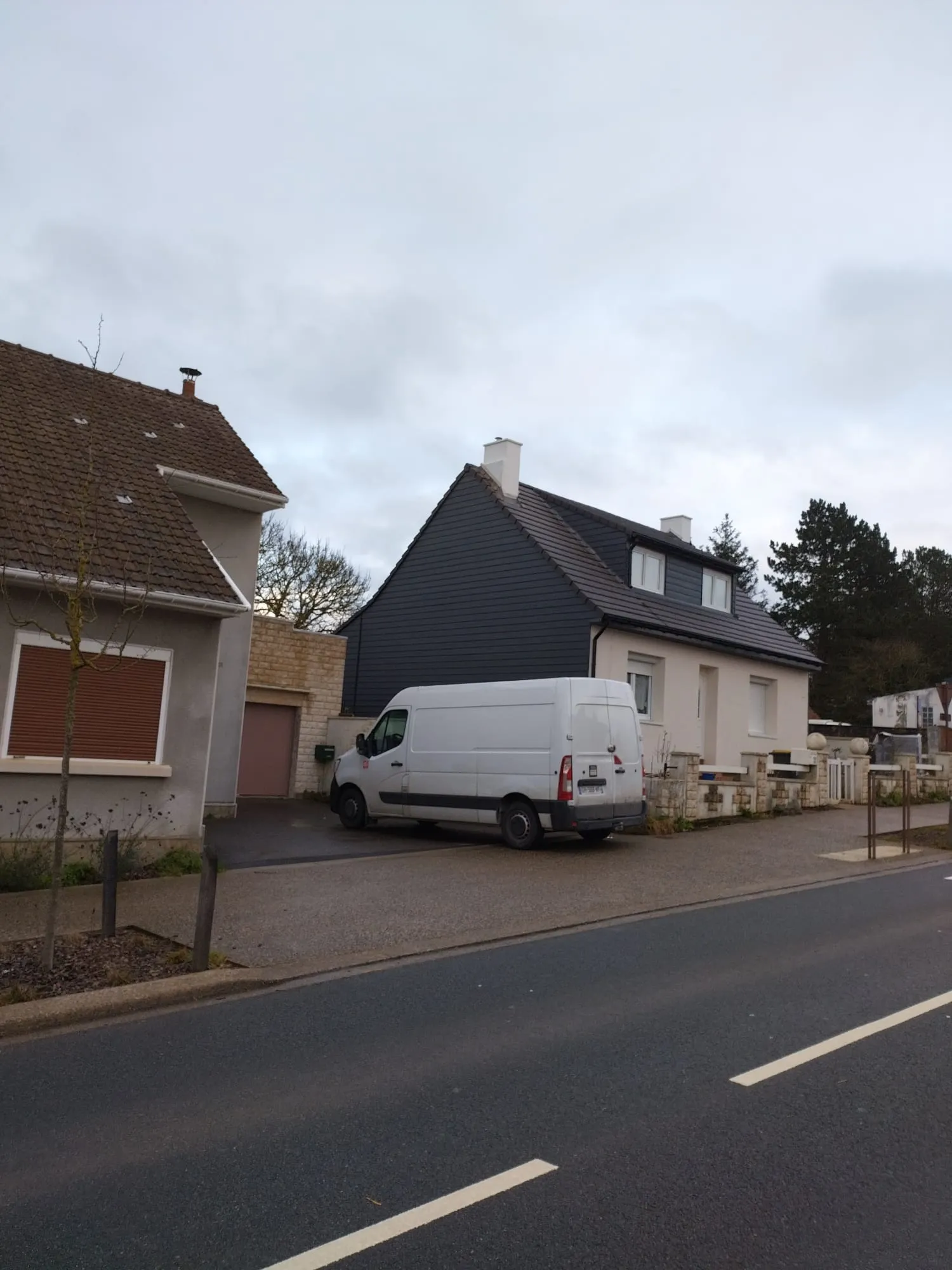 Vue de la rue : maison rénovée, toiture et bardage neufs, camionnette KOS garée devant