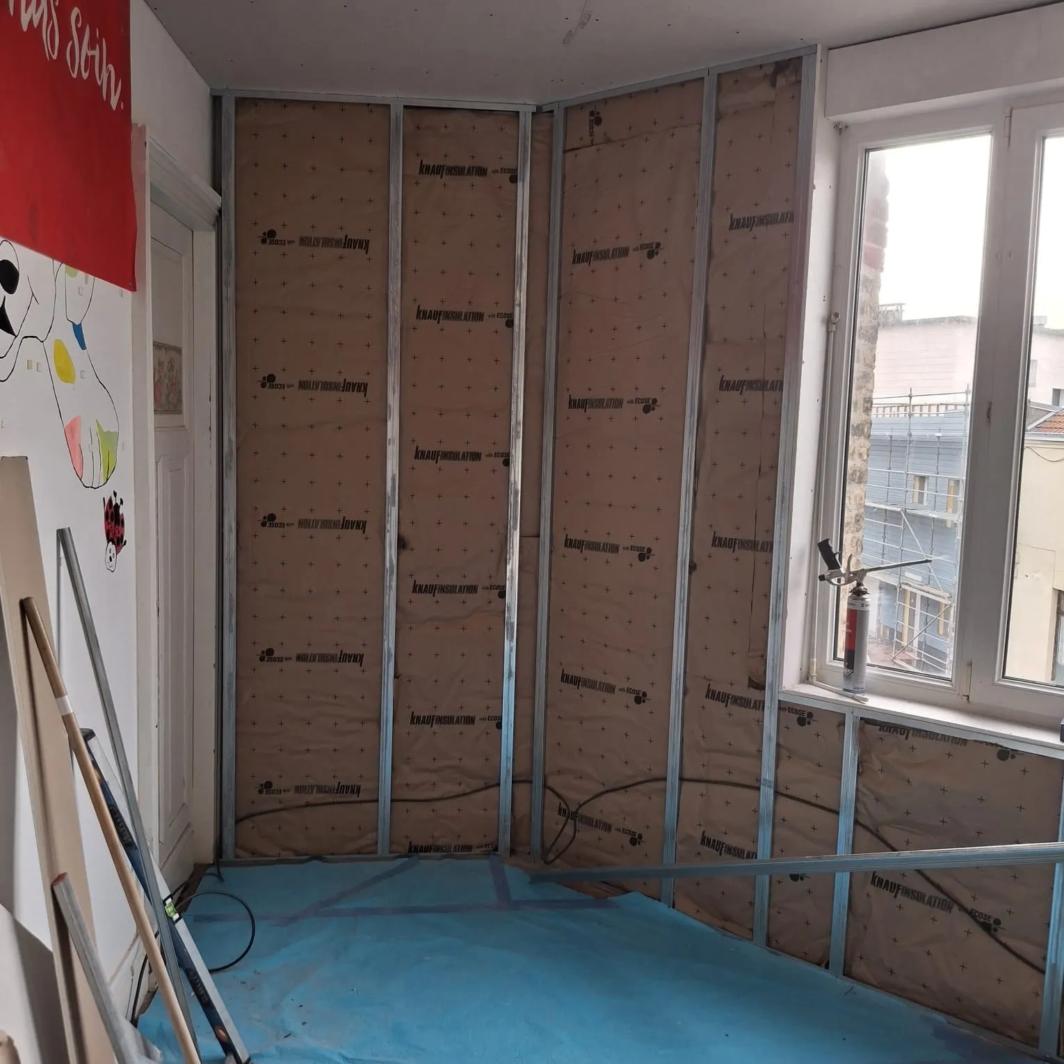 Ossature métallique et isolant posés sur les murs d'une chambre, à Calais