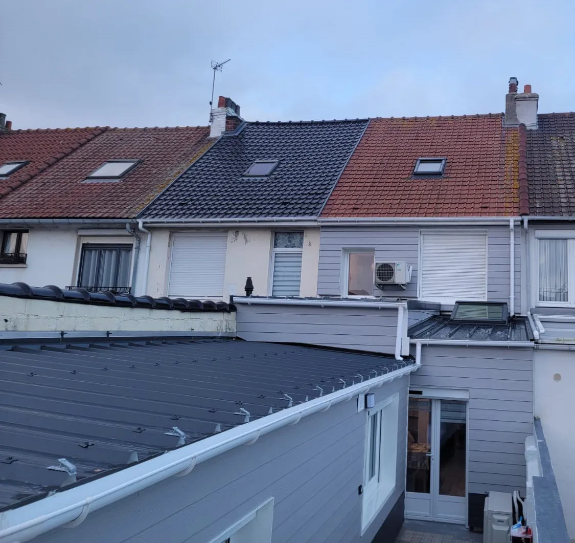 Toiture en bac acier et bardage vus depuis l'étage, maisons mitoyennes de Calais en fond