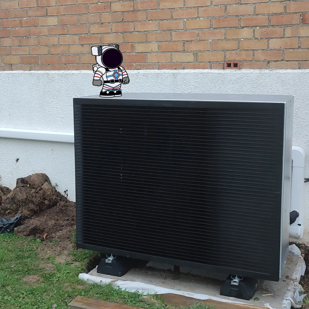 Unité extérieure noire de la pompe à chaleur Daikin posée contre la façade, à Hazebrouck
