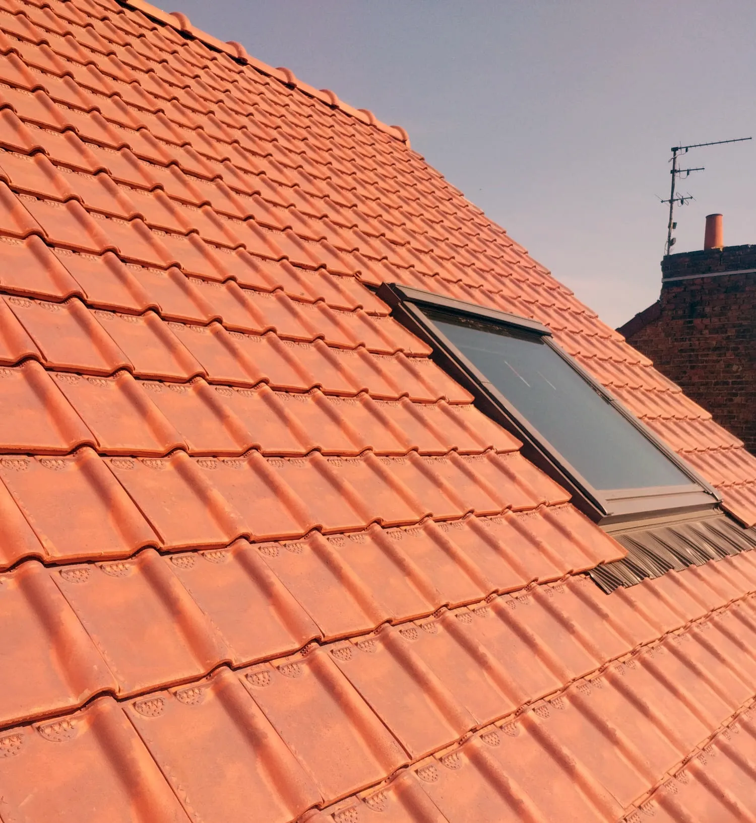 Toiture en tuiles rénovée avec fenêtre de toit, à Merville