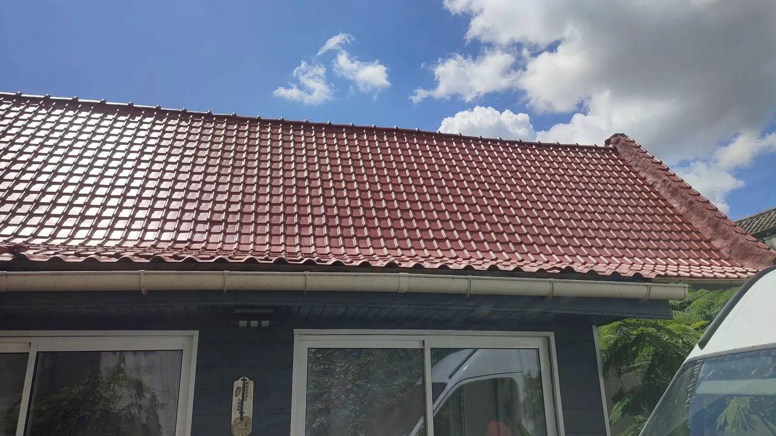 Pan de toiture hydrofugé rouge corail au-dessus de la baie vitrée
